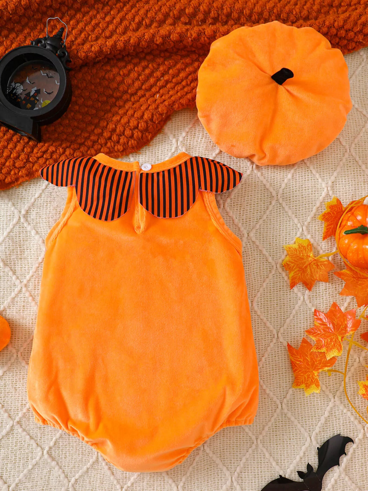 Back of the orange Halloween baby bodysuit beside its matching hat