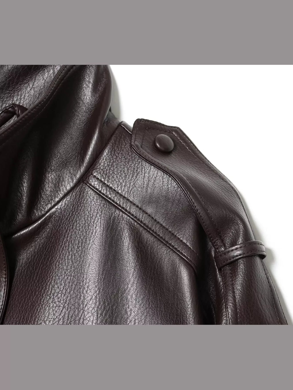 Close-up of the coffee-brown jacket's finish and shoulder tab.