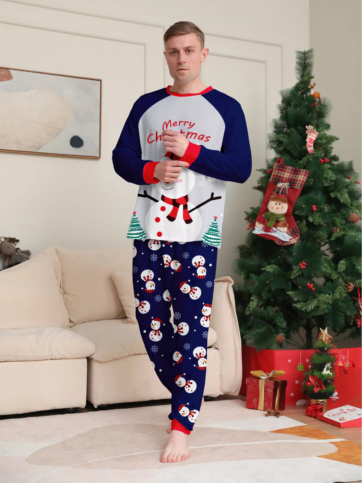Man modeling a white Merry Christmas snowman top and navy printed pajama pants.