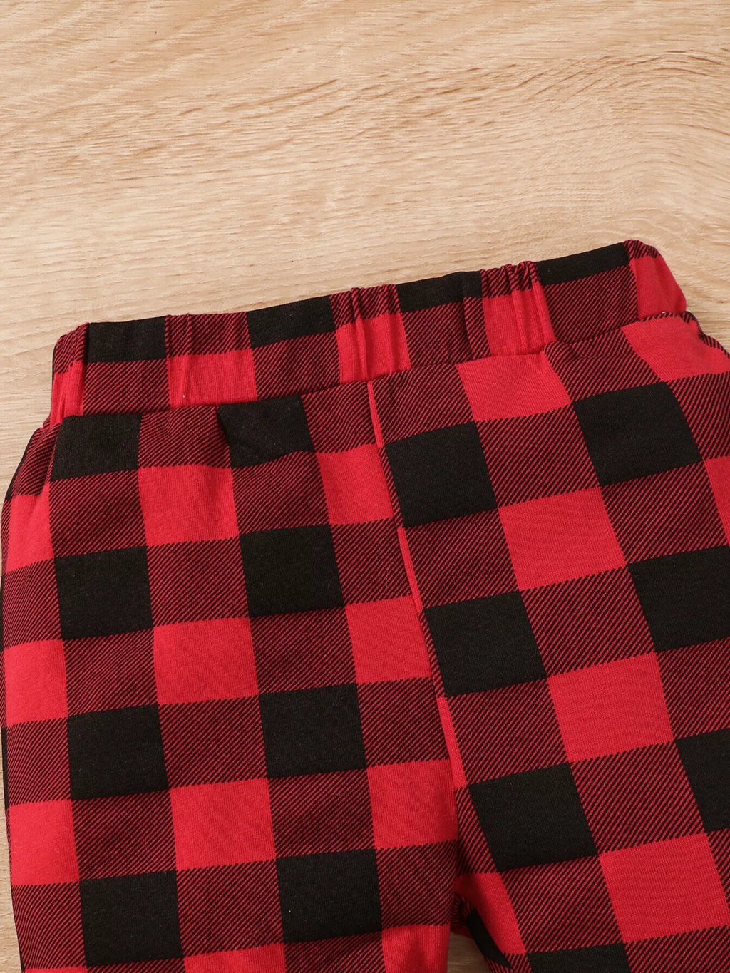 Close-up of the red and black plaid pants' waistband.
