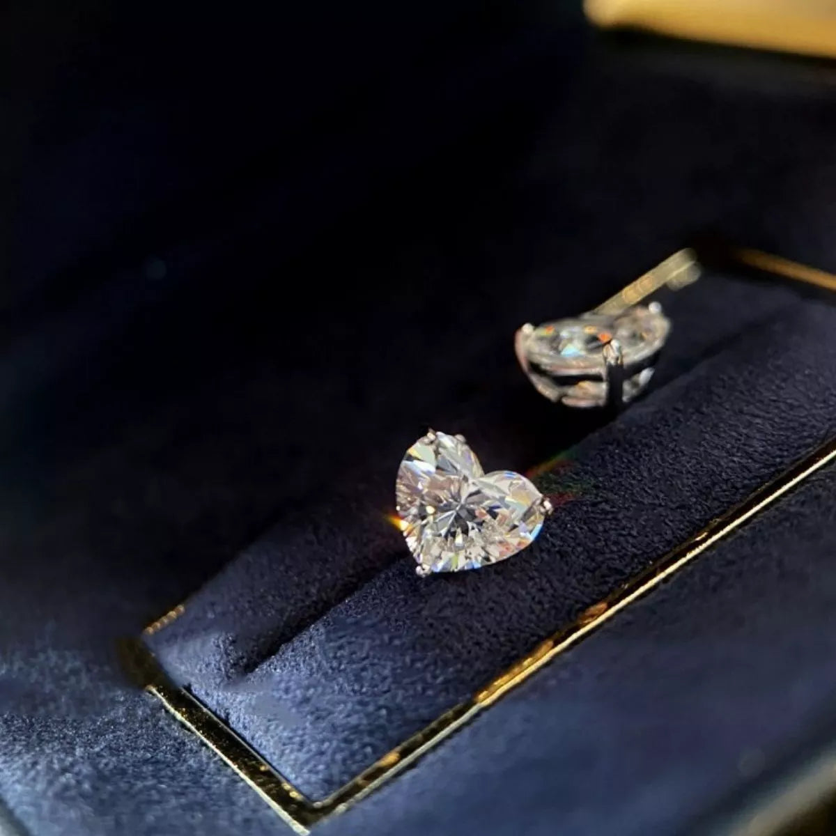 Silver-tone heart-shaped clear stone stud earrings — detail view