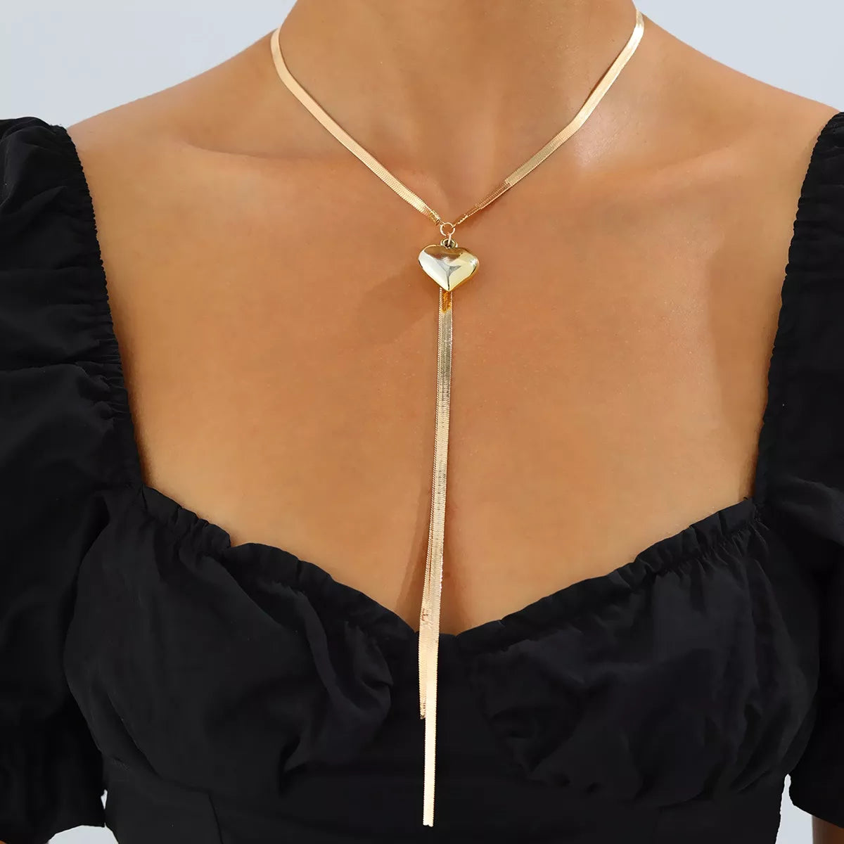 Gold-tone heart pendant lariat necklace with long chain tassels