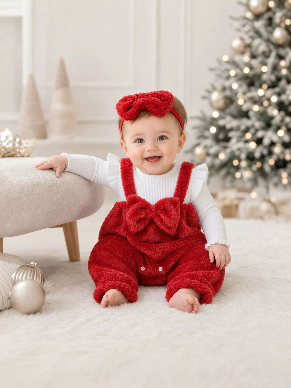 Red fuzzy baby overalls and matching bow headband with a white long-sleeve top worn by a baby