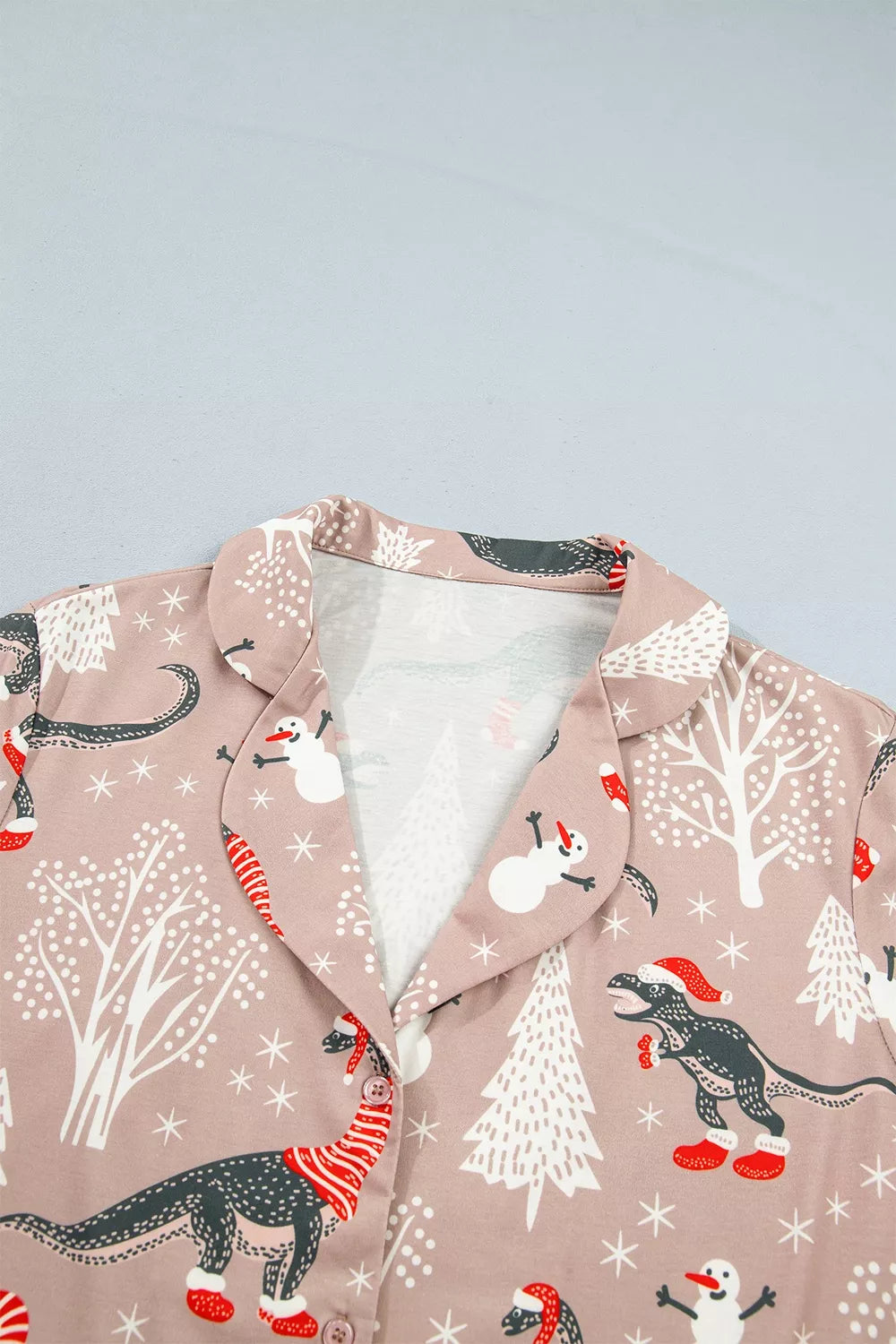 Pink long-sleeve pajama shirt and pants with dinosaur Christmas print — detail view