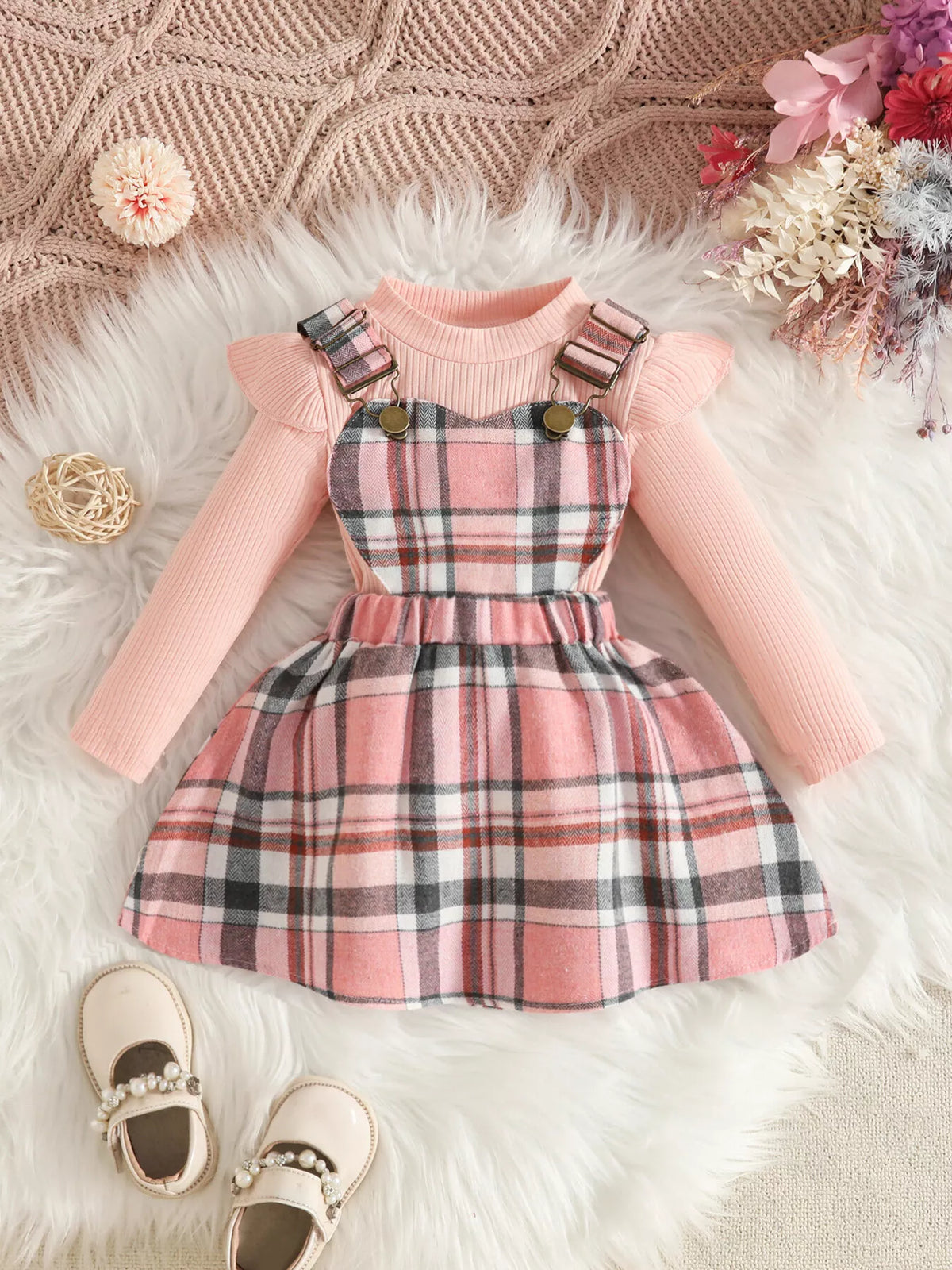 Pink ruffle-shoulder top paired with a pink plaid suspender skirt.