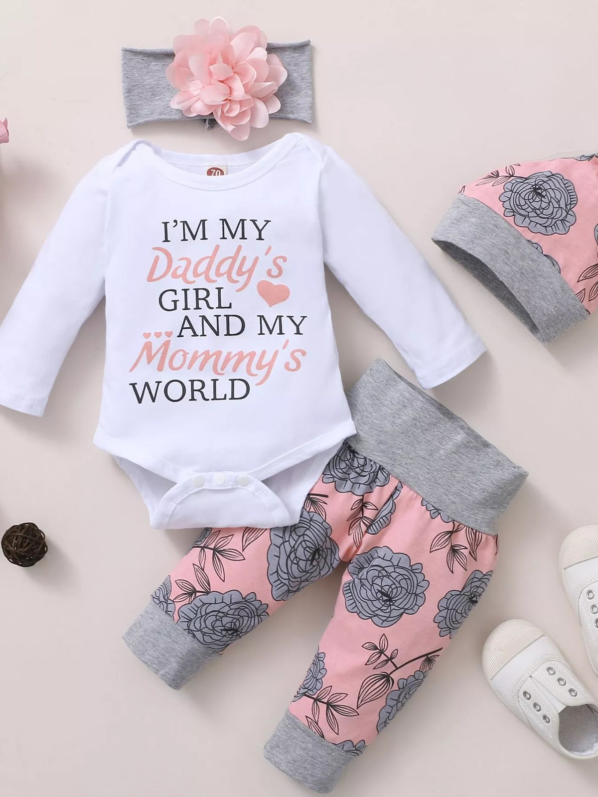 White letter graphic baby bodysuit, pink floral pants, flower headband and matching hat displayed flat