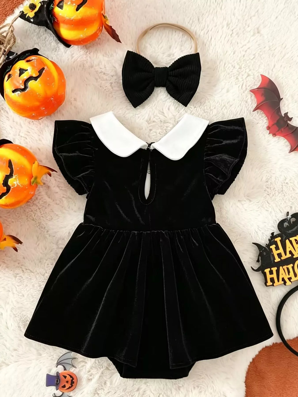 Back flat lay of the black dress-style romper and matching bow headband.