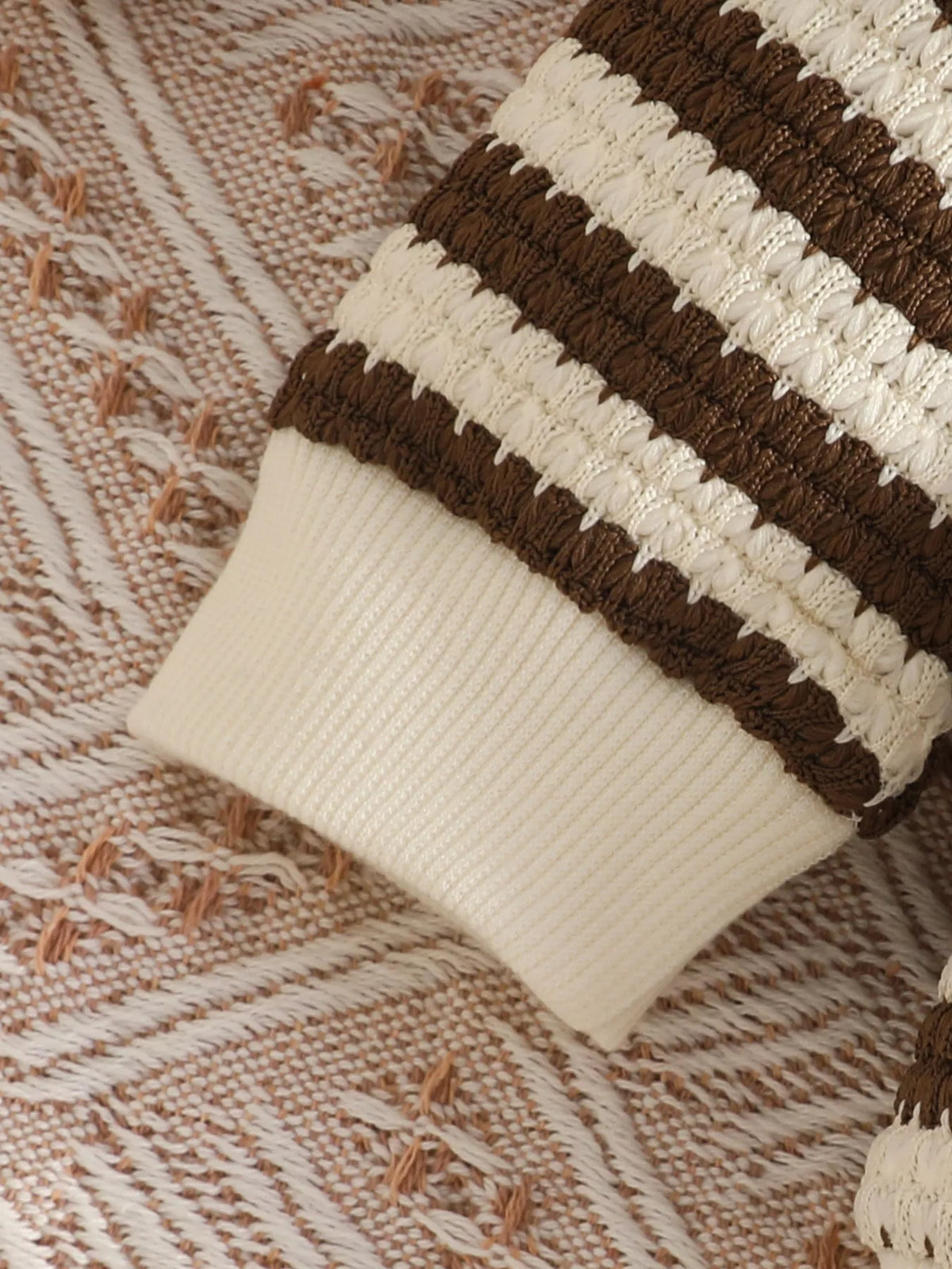 Cream cuff and brown striped knit sleeve detail