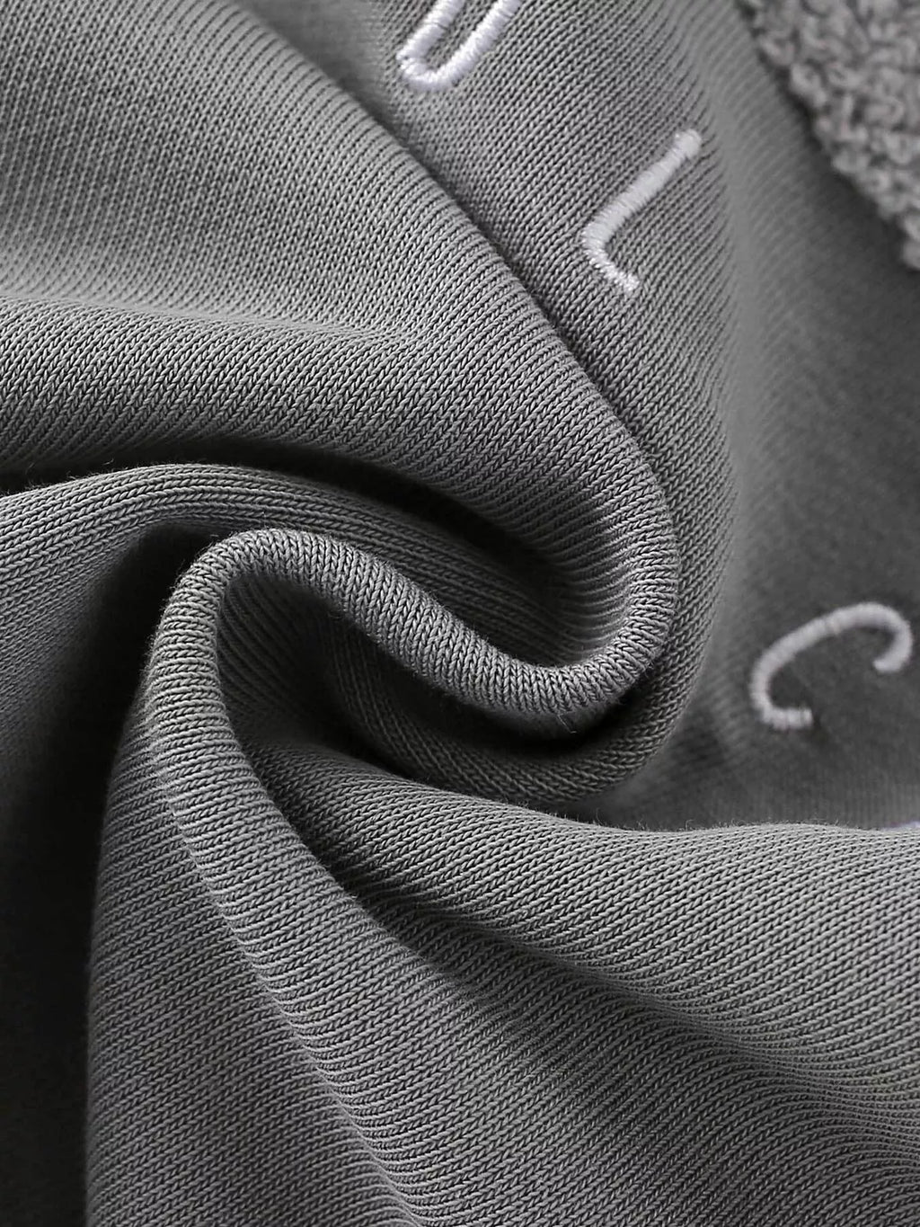 Folded gray sweatshirt fabric with part of the Cool Car lettering.