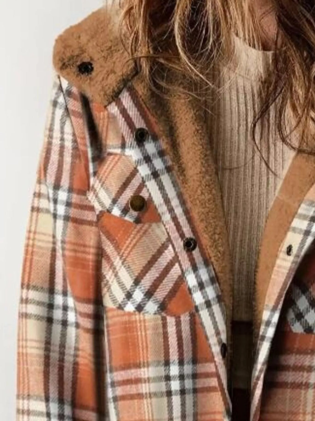 Close view of the orange plaid jacket's button front and plush hood lining.