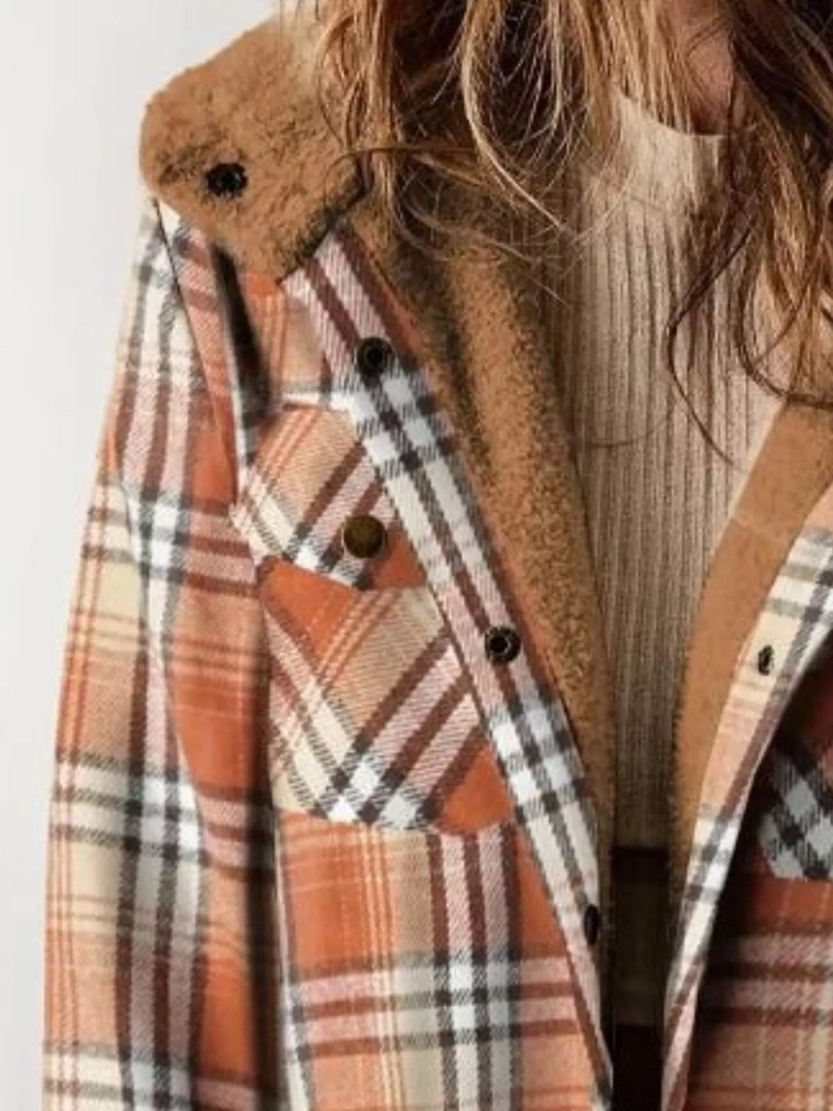 Close view of the orange plaid jacket's button front and plush hood lining.