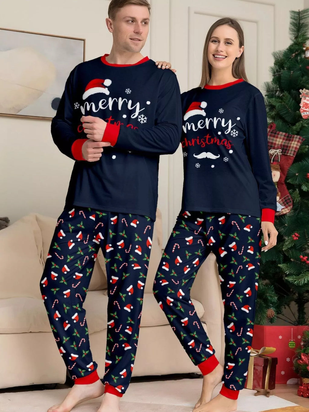 Adults modeling navy Merry Christmas tops and matching printed pajama pants.