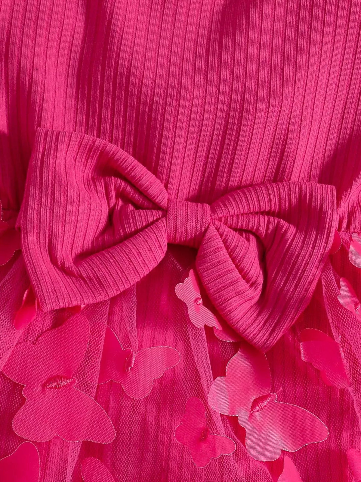 Large bow and ruffle trim on the hot pink ribbed baby bodysuit