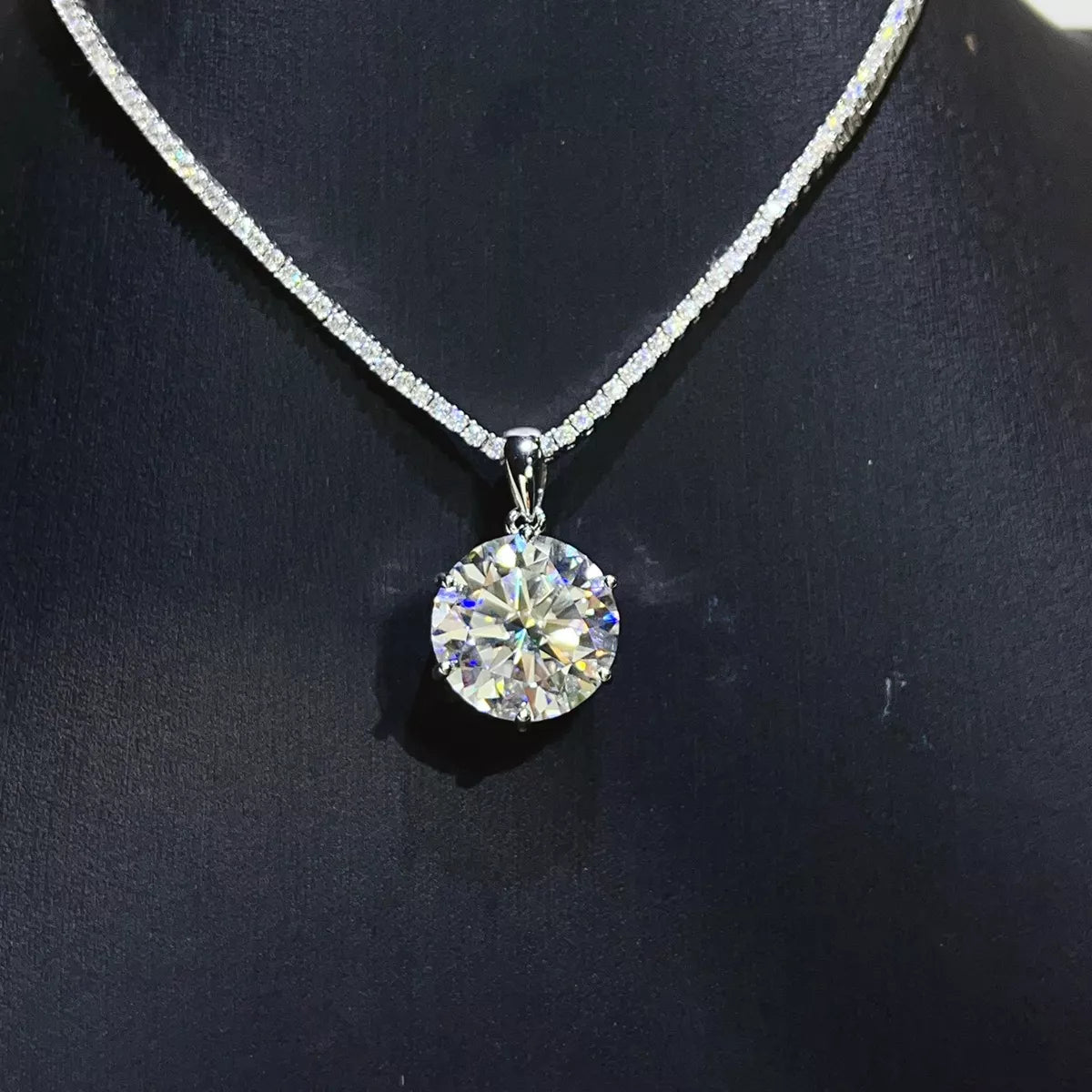 Silver-tone necklace with a round clear stone pendant — detail view