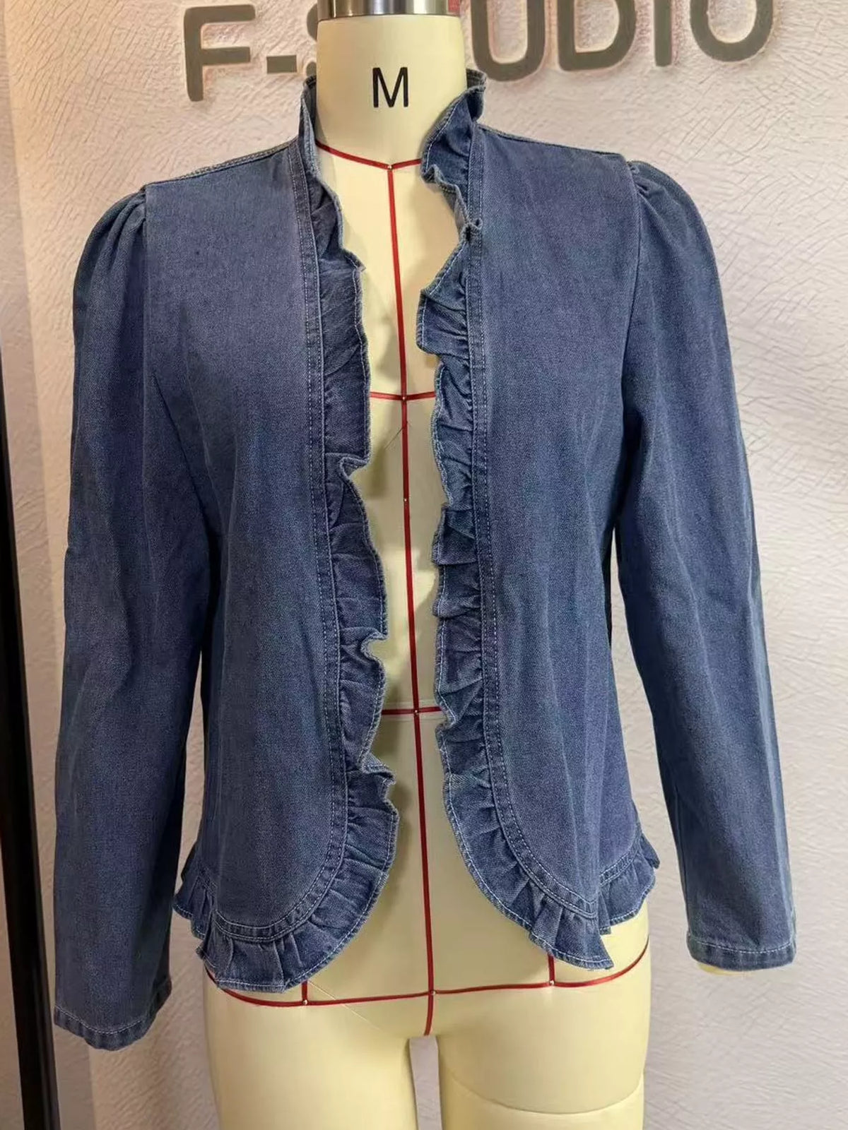 Blue ruffle-trim jacket shown on a mannequin.