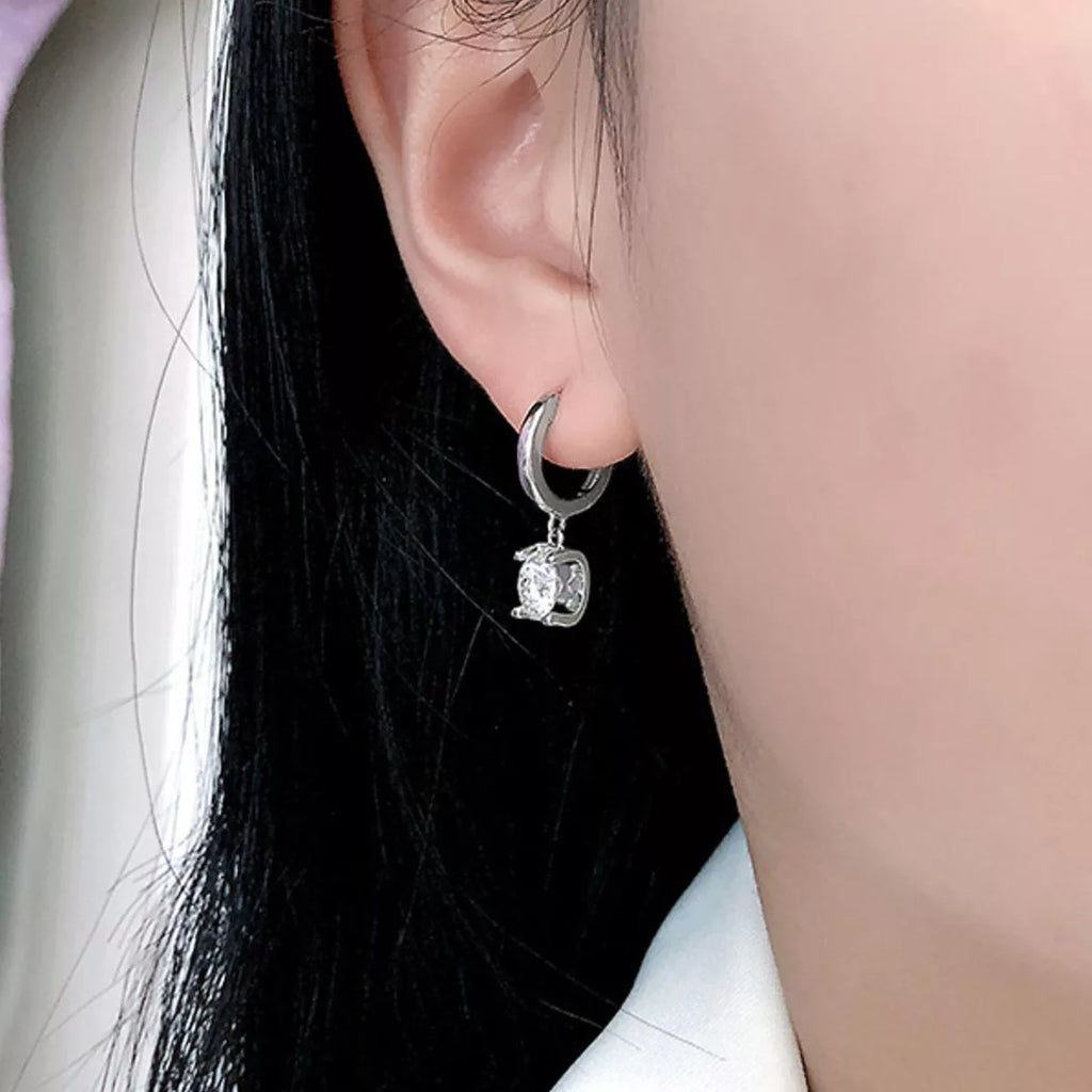 Silver-tone hoop earrings with square clear stone drops — detail view