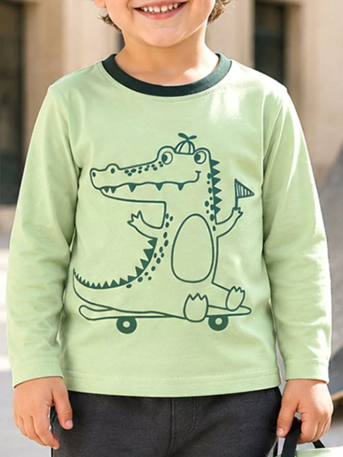 Light green long-sleeve T-shirt with a crocodile graphic worn by a child