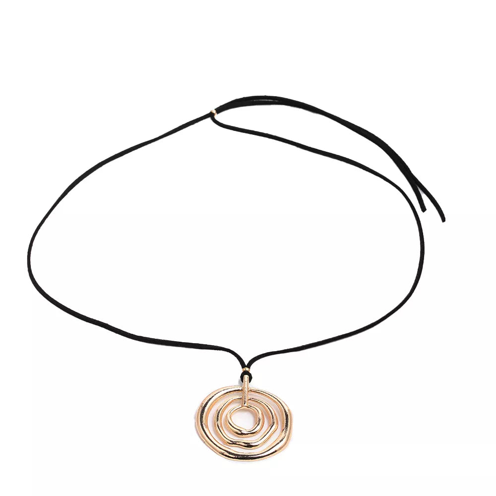Long black cord necklace with a round gold-tone spiral pendant — detail view