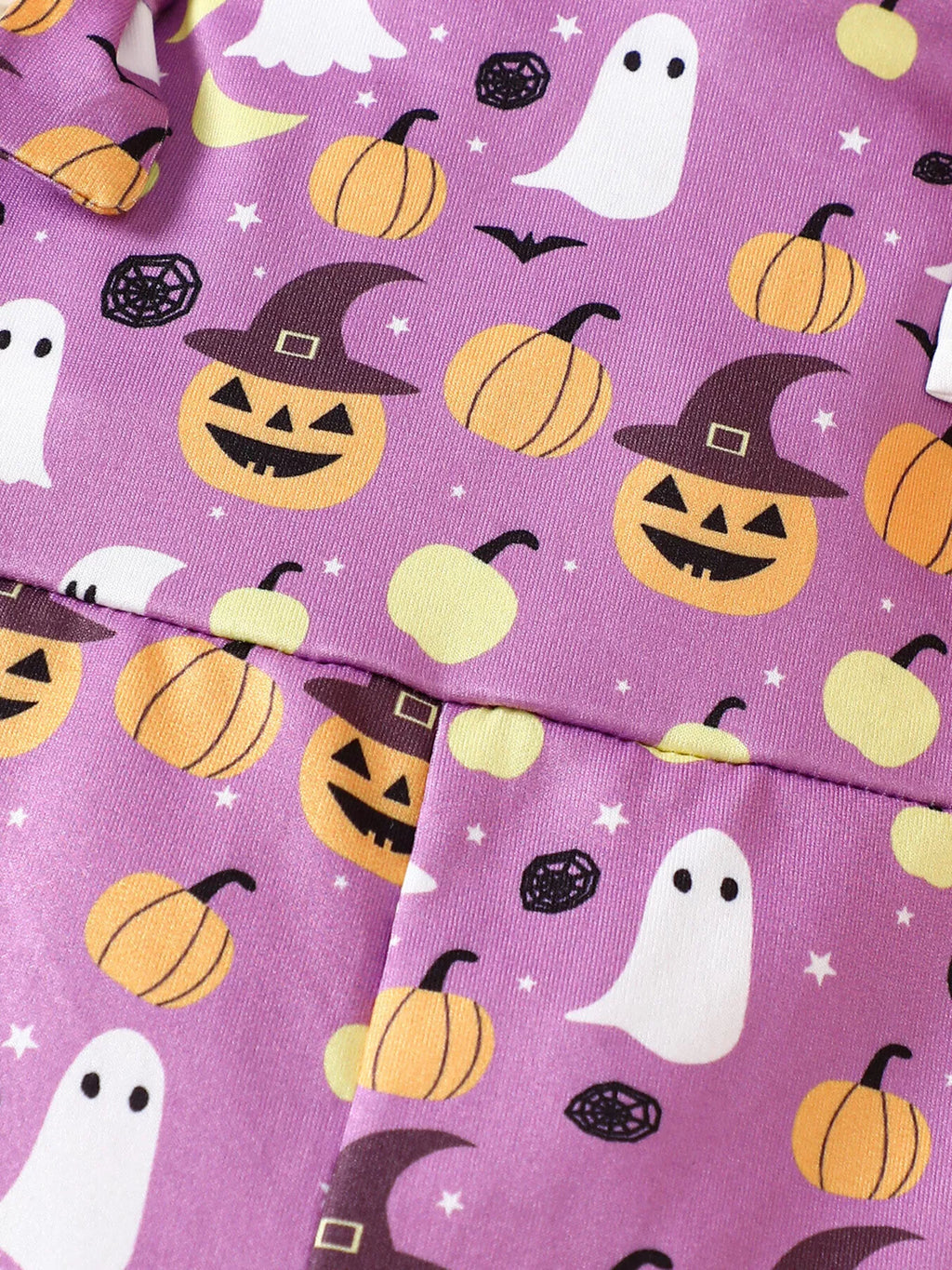 Close-up of the purple fabric with ghosts, jack-o'-lanterns, pumpkins and witch hats.