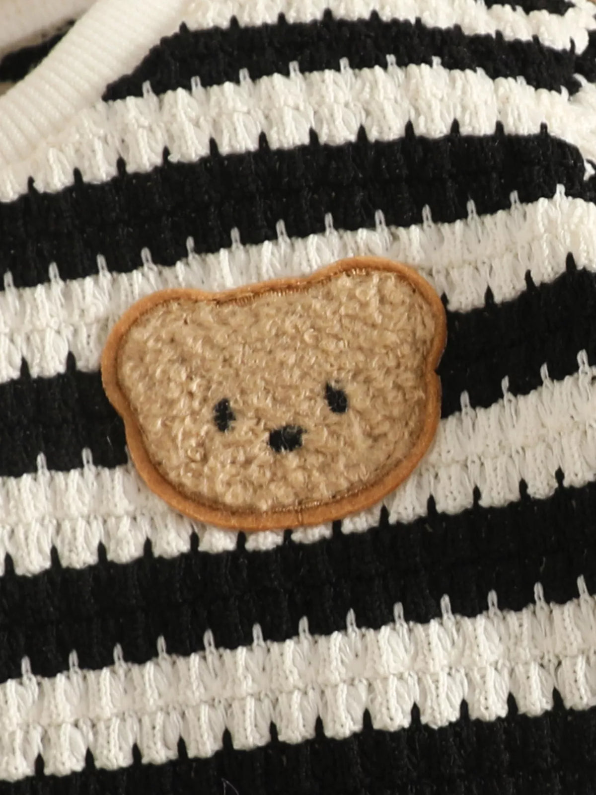 Bear-face patch on black and cream striped knit fabric