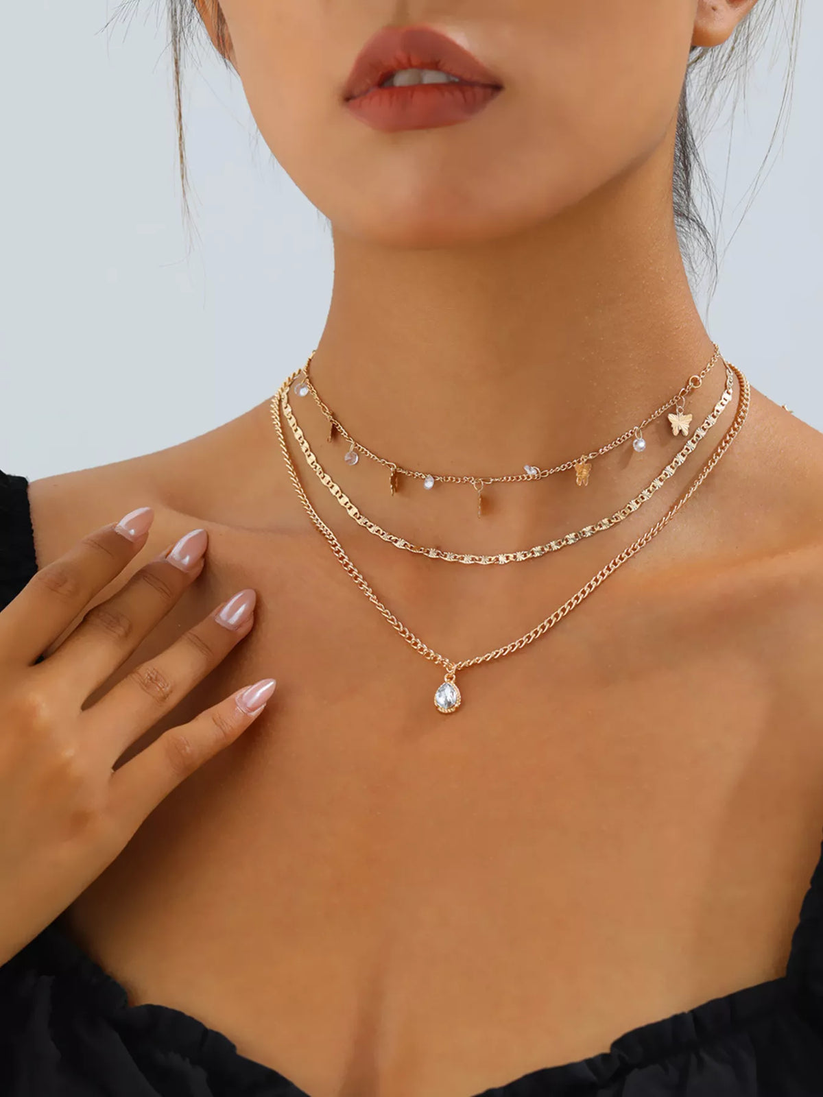 Layered gold-tone necklace with butterfly and clear stone charms