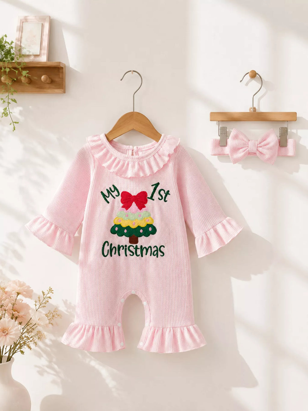 Pink My 1st Christmas romper with ruffle collar and flared legs displayed on a hanger.