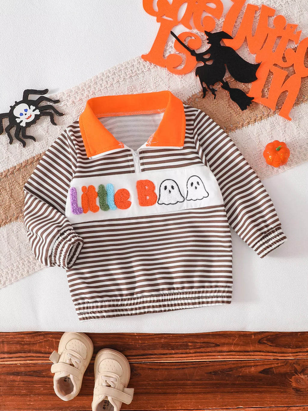 Brown-and-white striped children's half-zip top with orange collar and Little Boo ghost graphic.