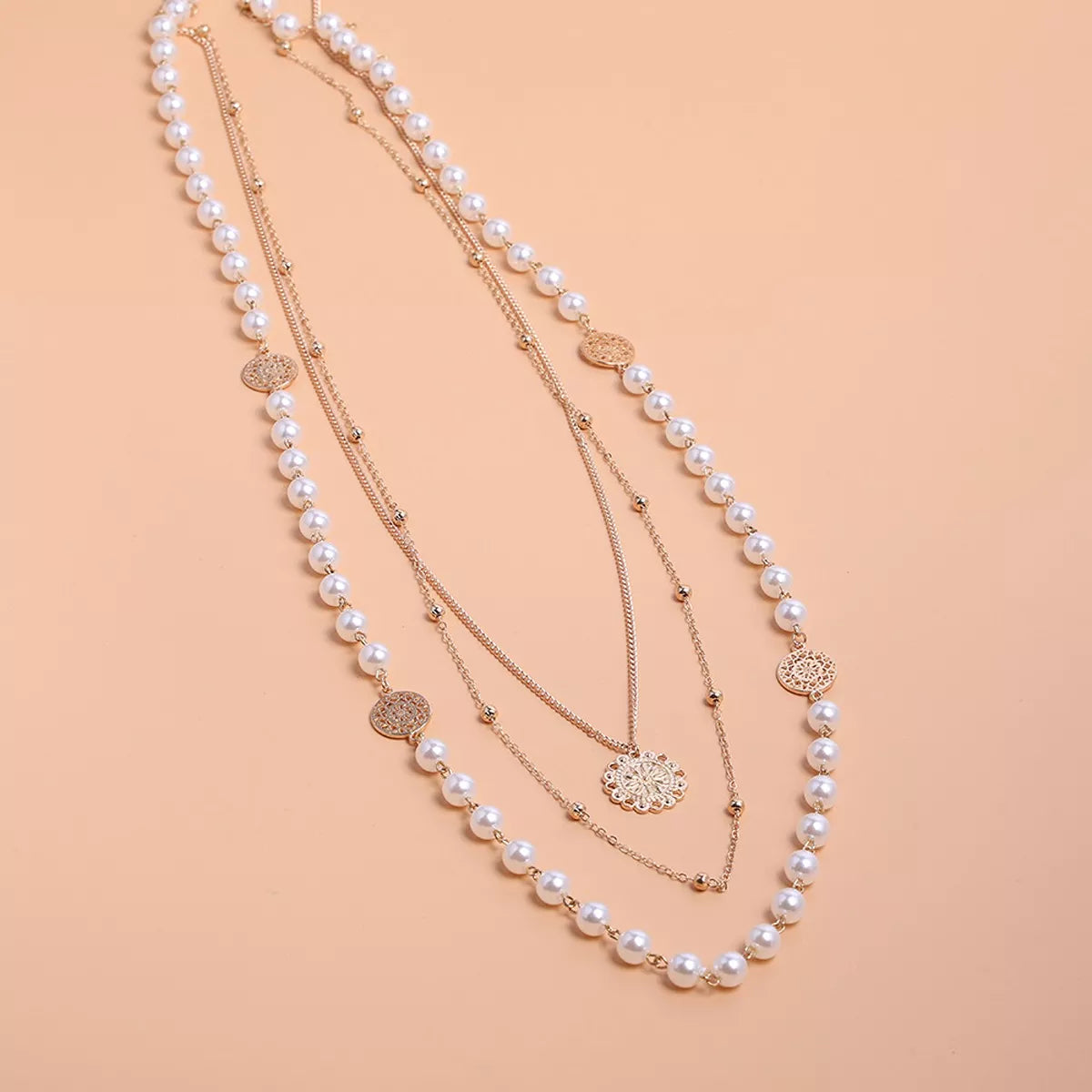 Layered pearl-like bead and coin pendant necklace — detail view