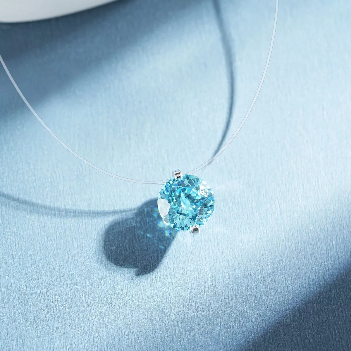 Silver-tone necklace with a round colored stone pendant — detail view