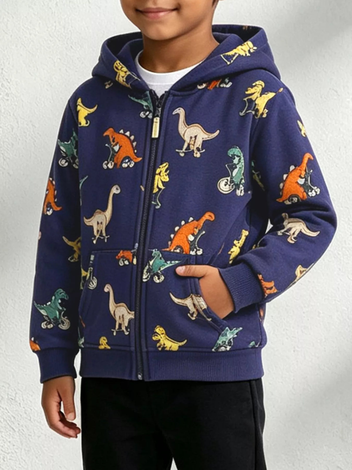 Front view of a child modeling the navy dinosaur-print zip-up jacket with pockets.