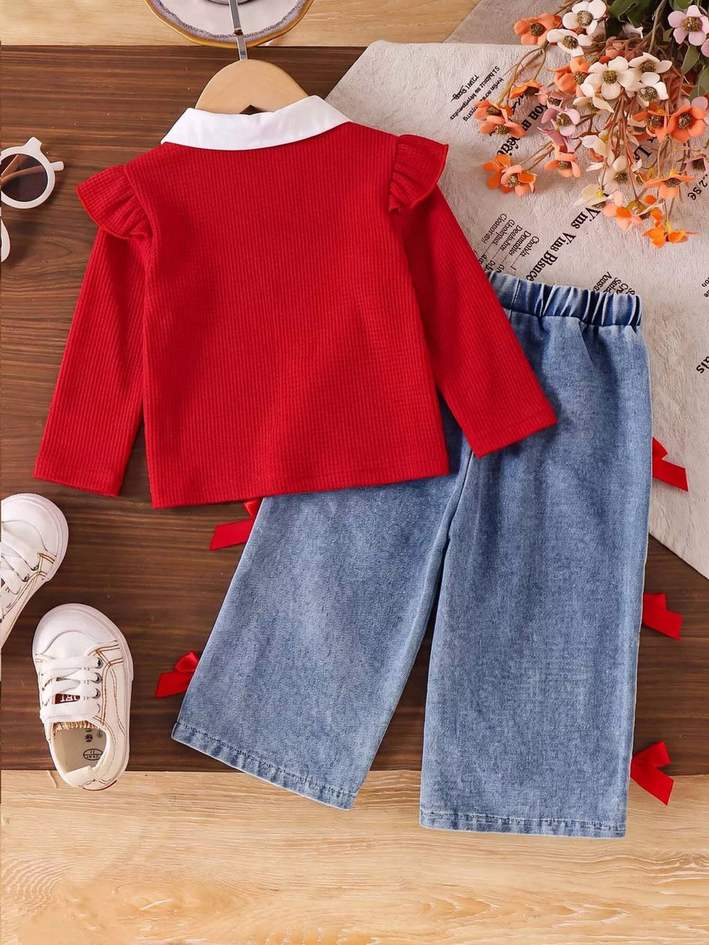 Children’s red bow-embellished sweater with white collar and blue jeans with red bows — back view