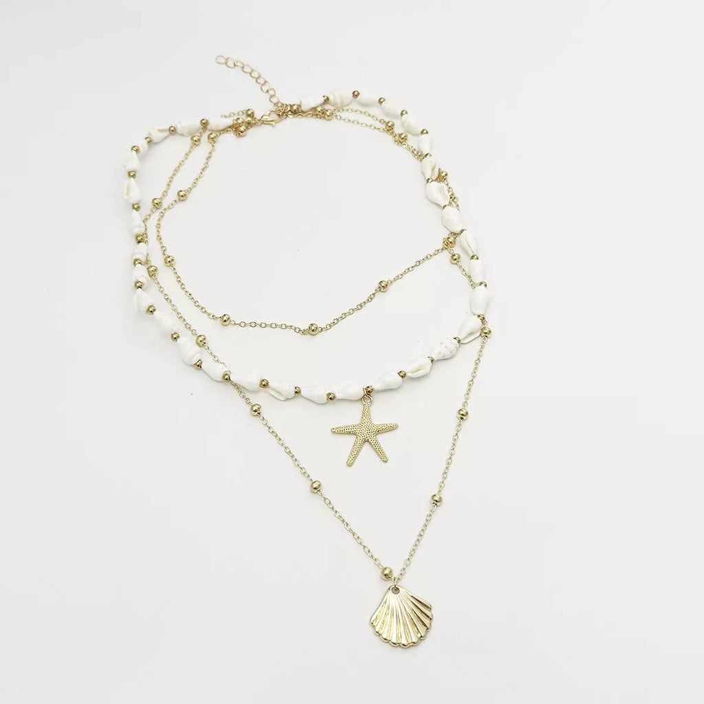 Layered gold-tone shell and starfish charm necklace — detail view
