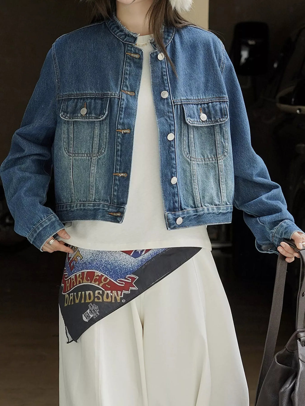 Blue cropped denim jacket modeled with arms extended.