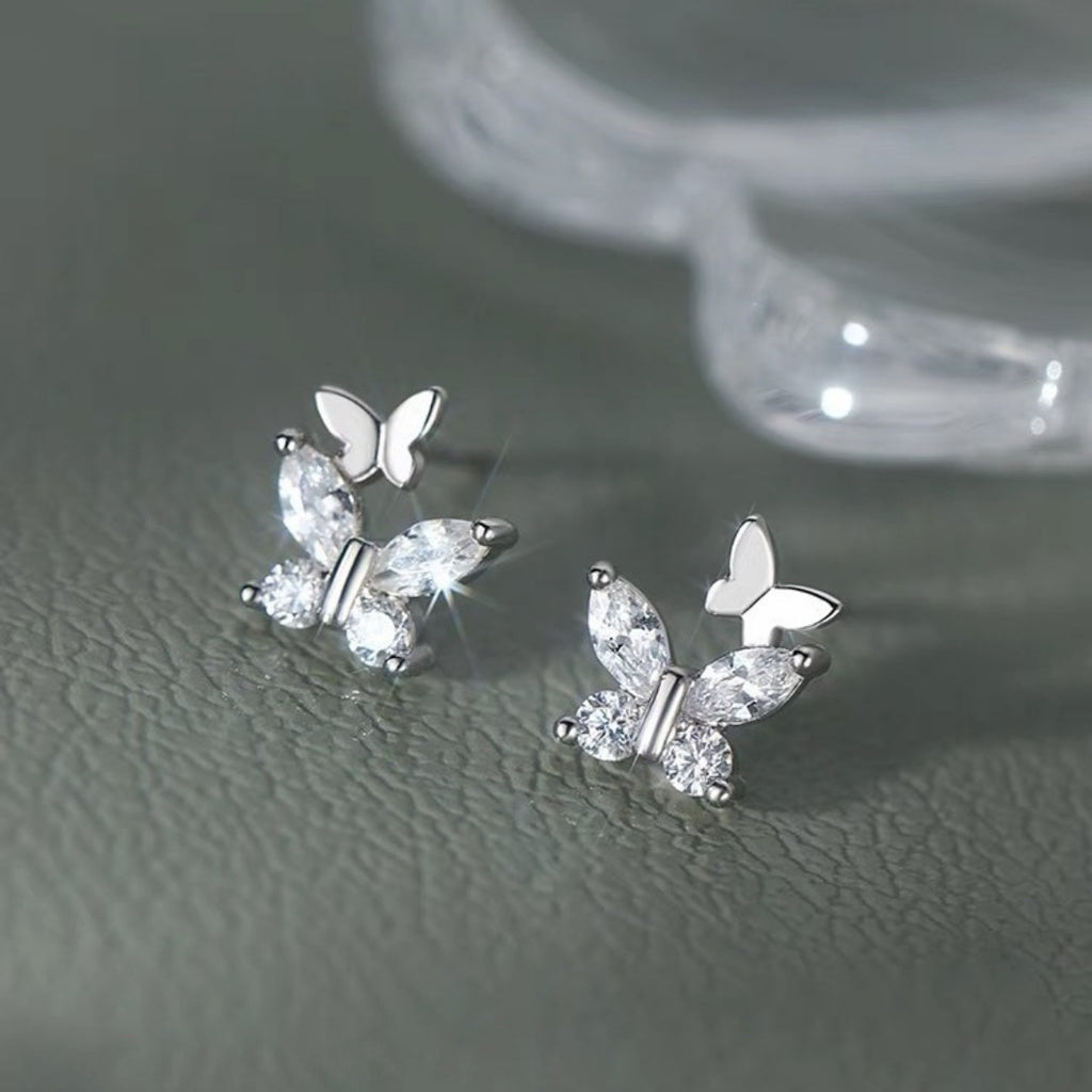 Silver-tone butterfly stud earrings with clear stones — detail view
