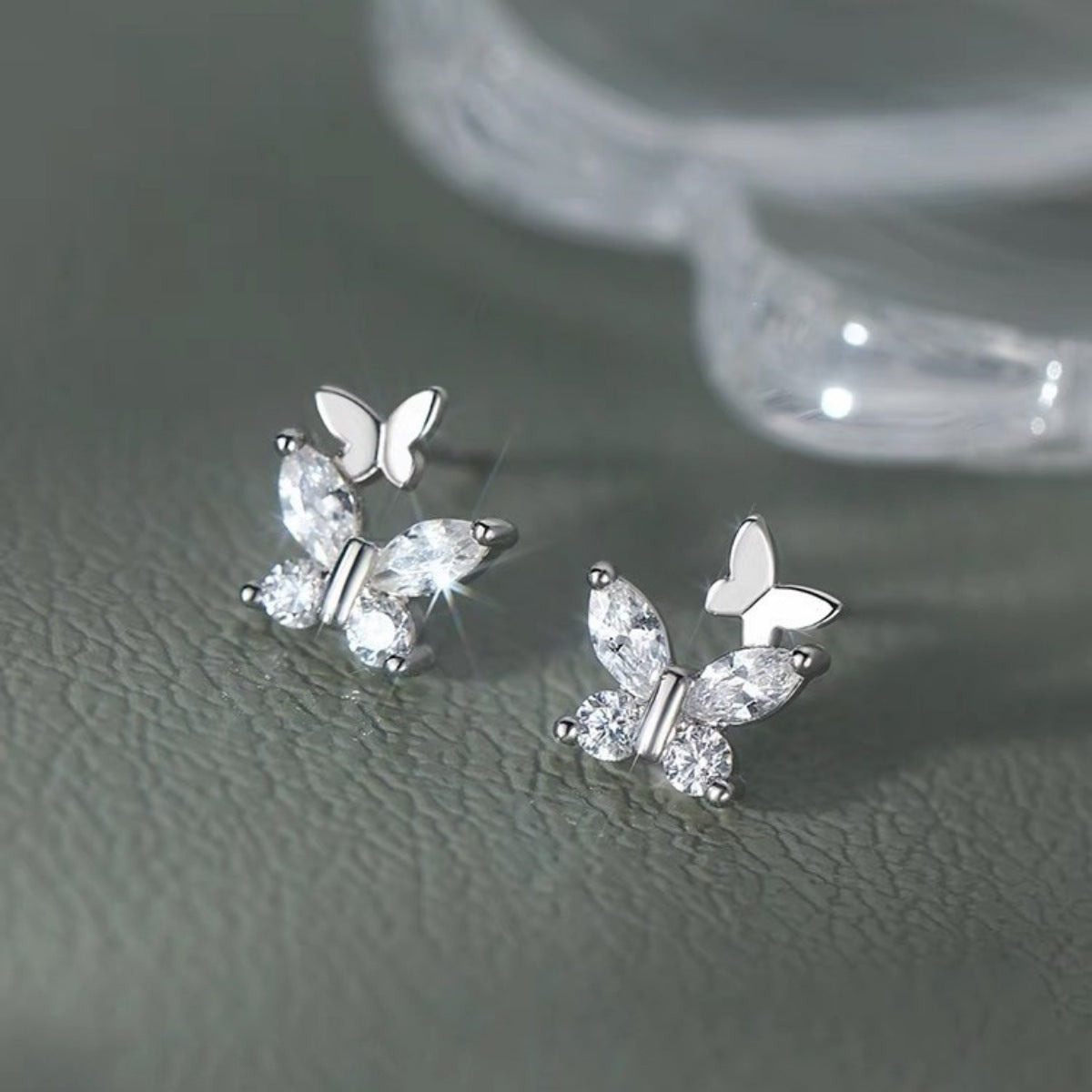 Silver-tone butterfly stud earrings with clear stones — detail view