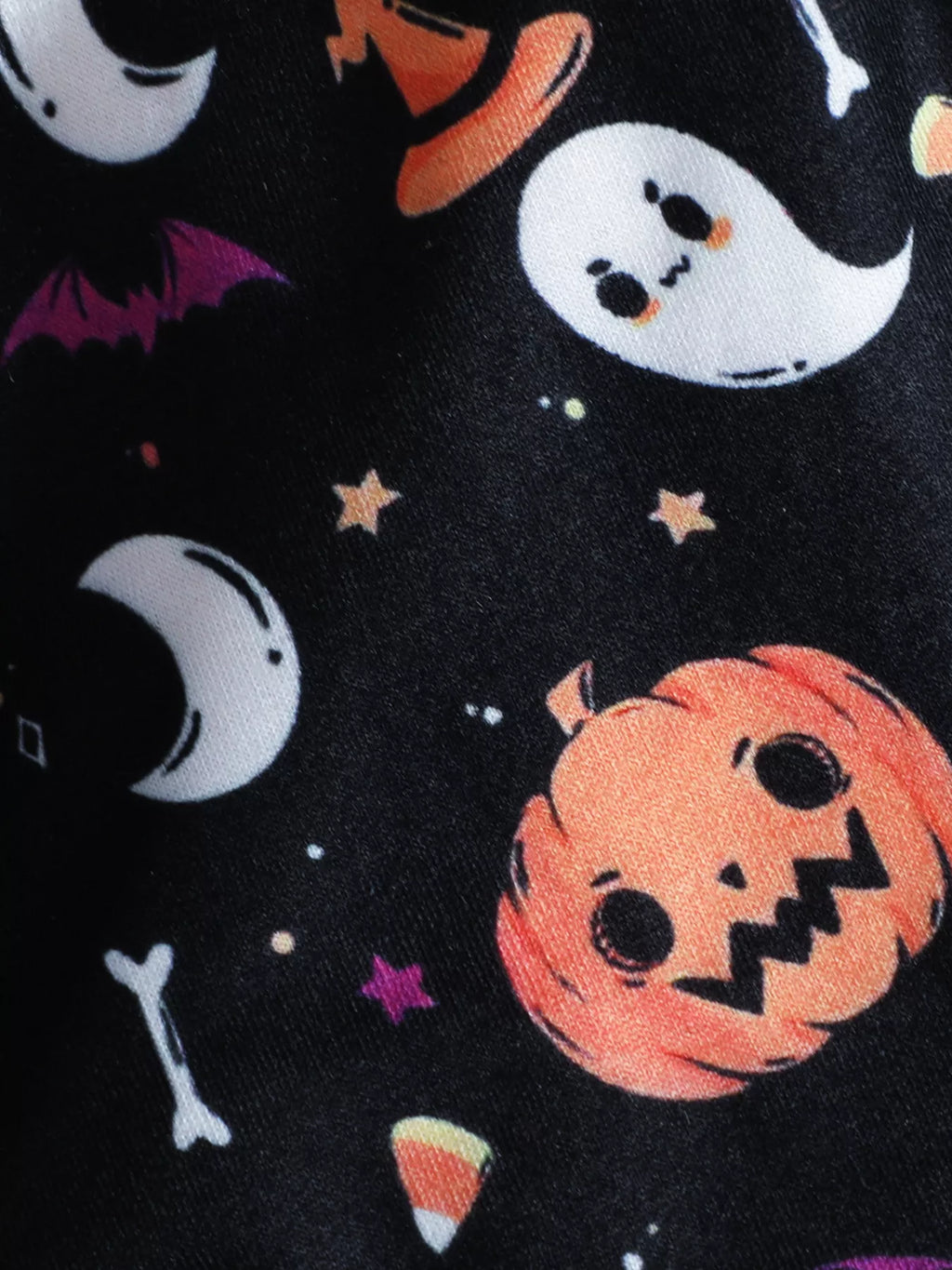 Close-up of the cape fabric with pumpkins, ghosts, moons and Halloween prints.