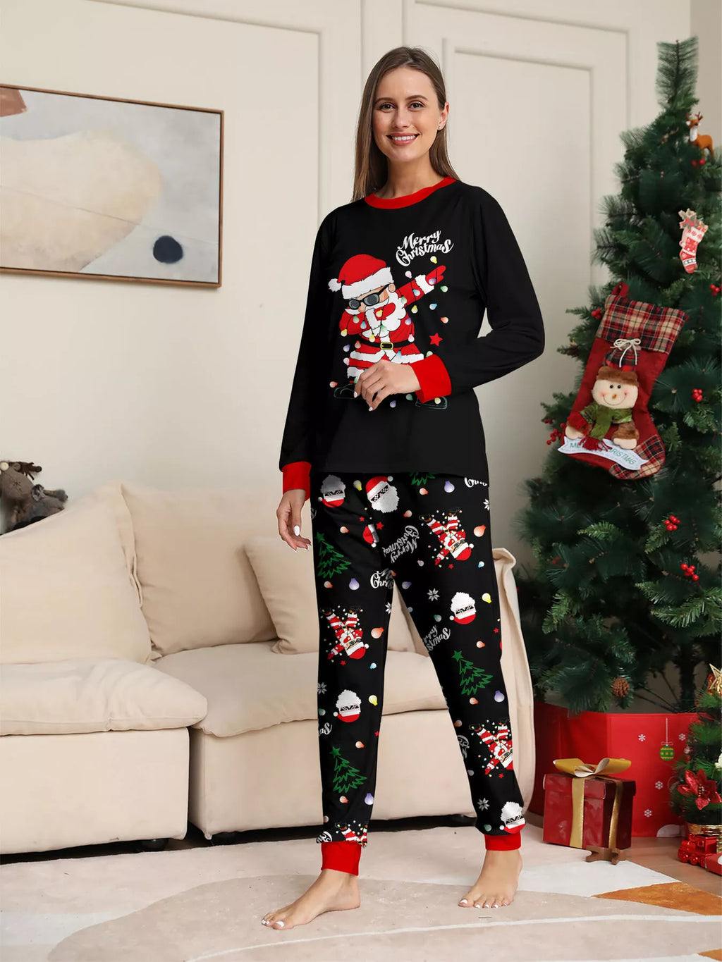 Woman modeling a black Santa graphic top and black Christmas-print pajama pants.