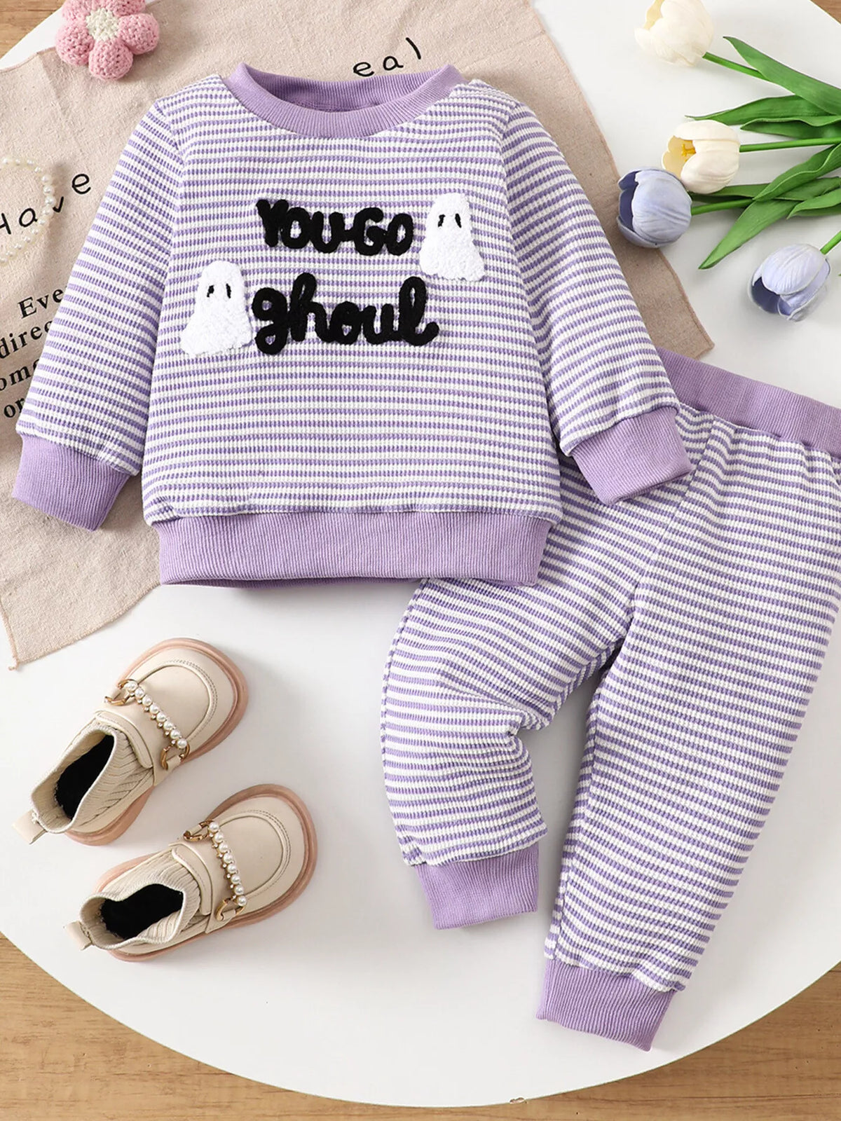 Purple striped ghost graphic pajama top and matching pants displayed flat
