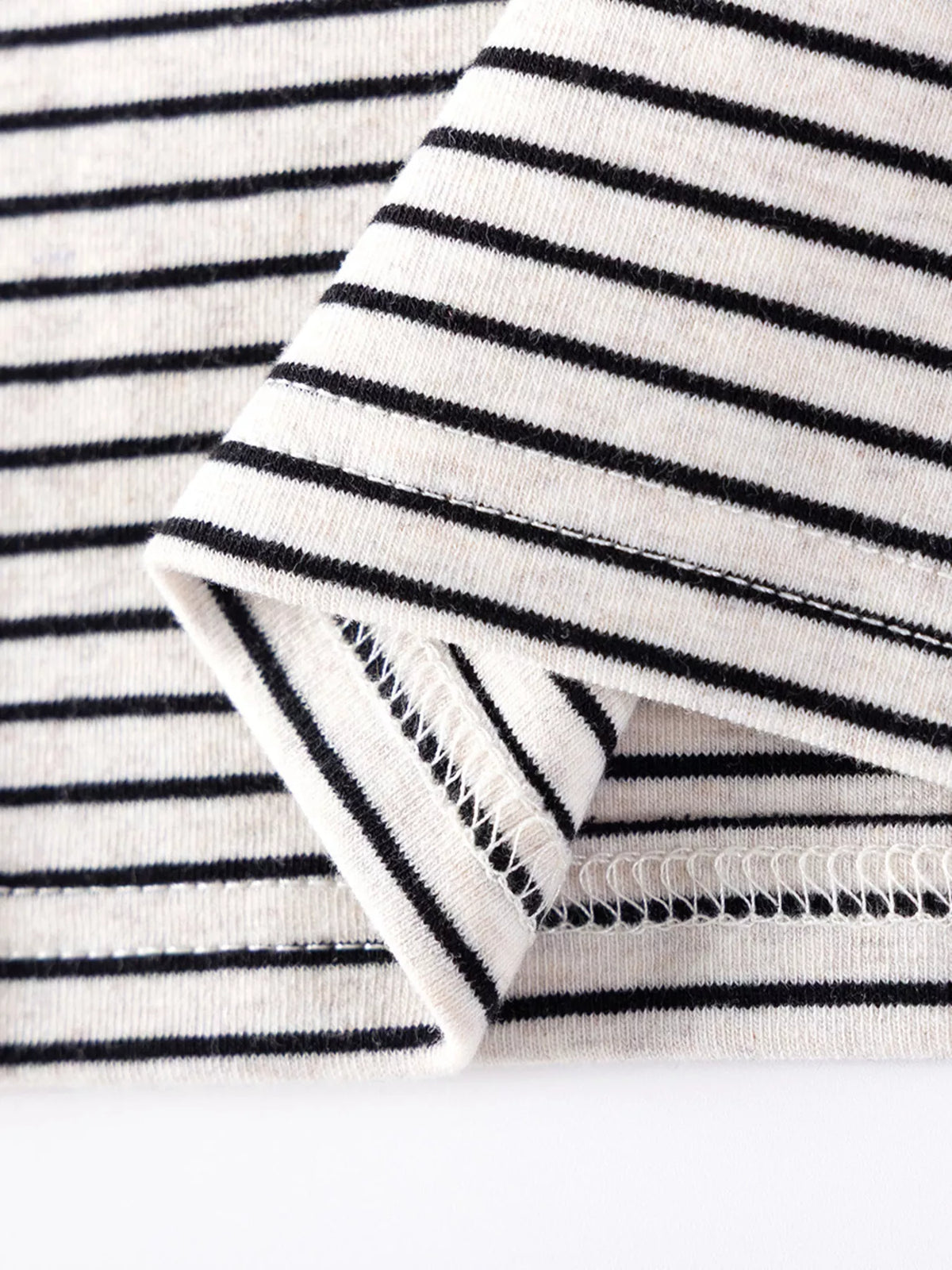 Close-up of the striped top's sleeve cuff and hem stitching.