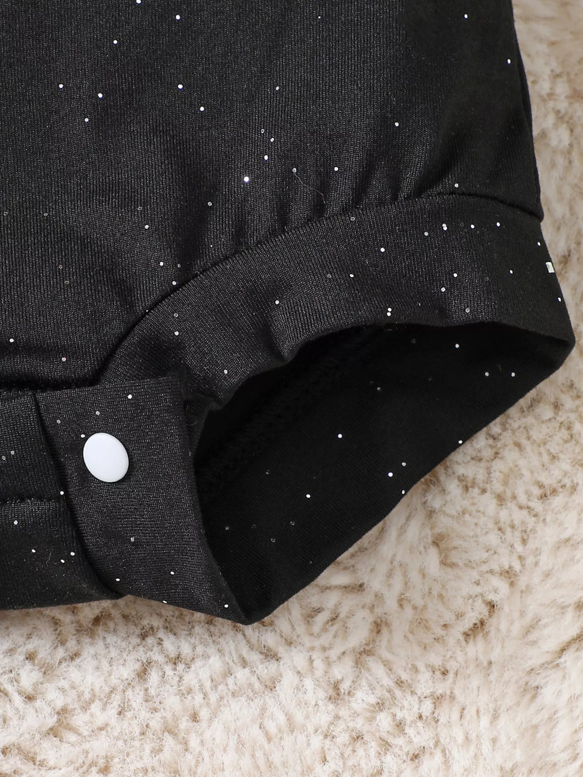 Leg opening detail on the black baby bodysuit