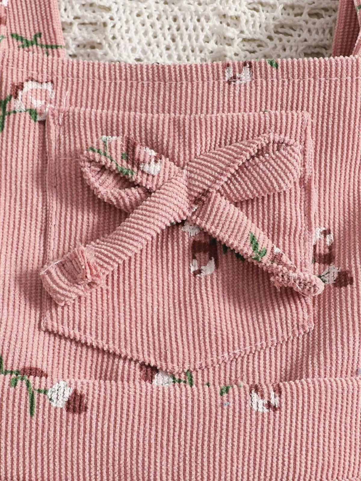 Bow and ribbed fabric detail on the pink overalls