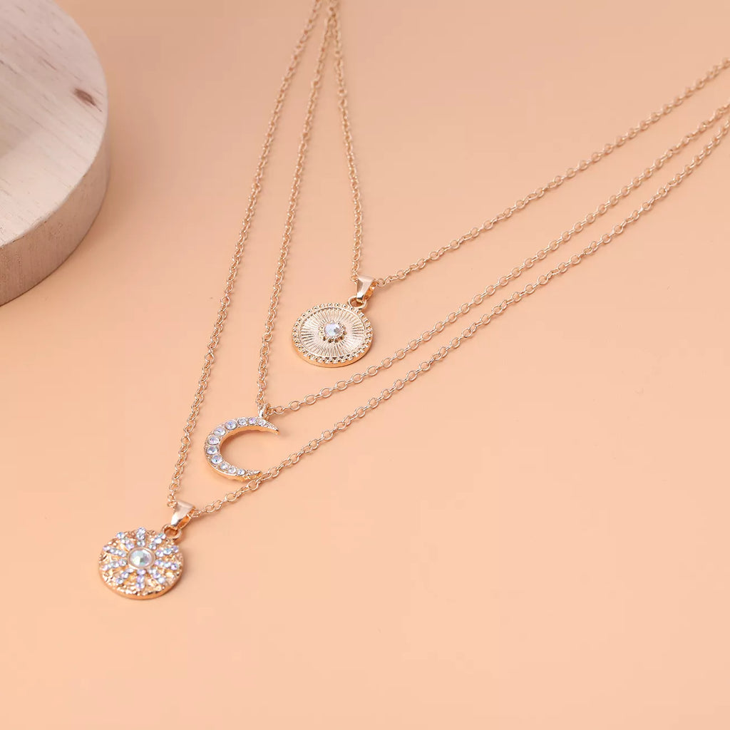 Layered gold-tone moon and coin pendant necklace — detail view