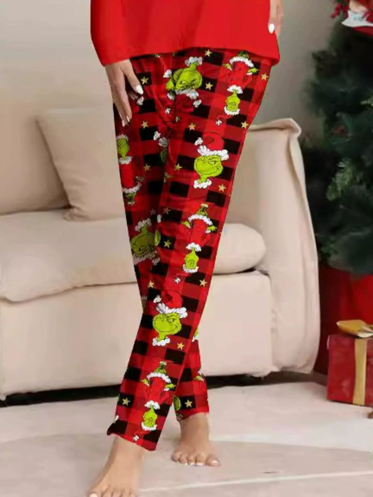 Red pajama pants with green Grinch faces and festive print