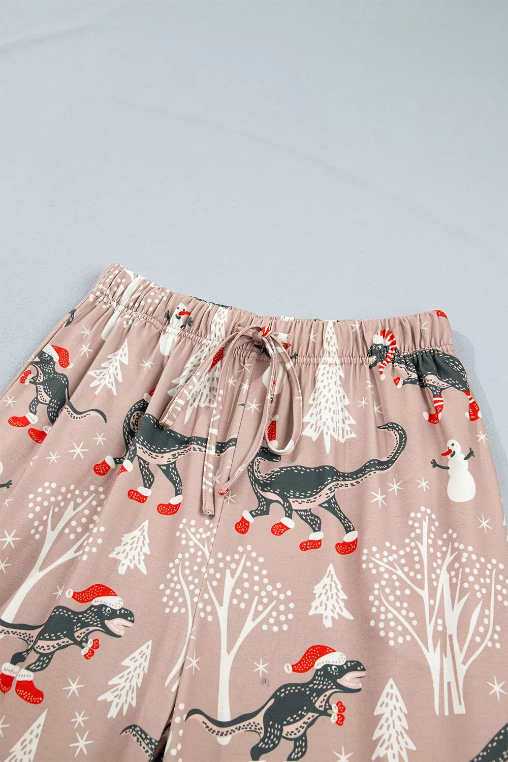 Pink long-sleeve pajama shirt and pants with dinosaur Christmas print — detail view