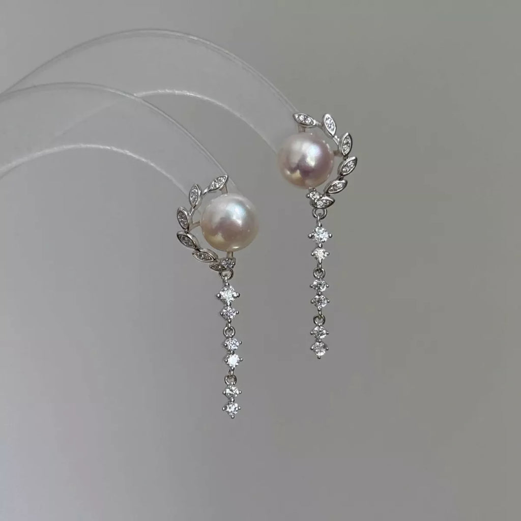 Pearl-like bead drop earrings with long dangling clear stone chains — detail view