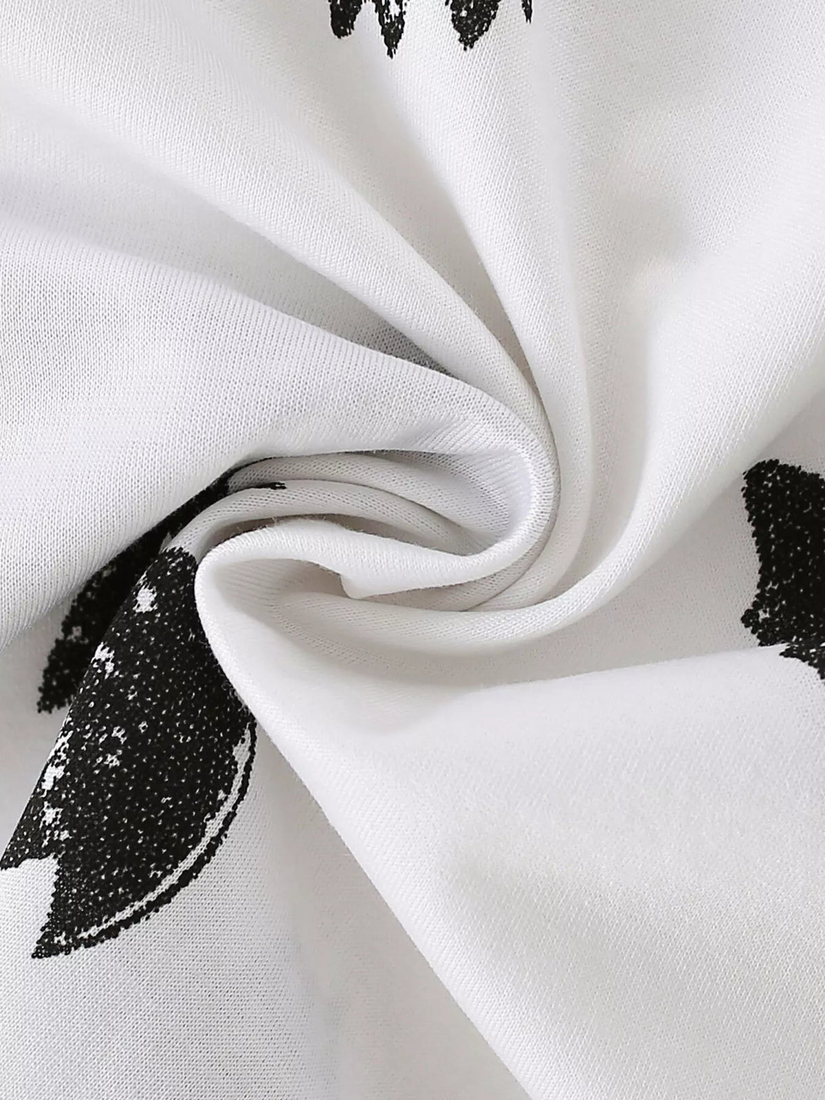 Folded white fabric showing the black bat print.