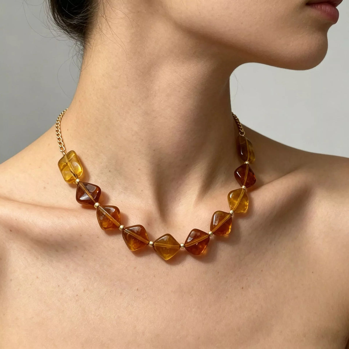Gold-tone necklace with angular amber-colored beads — detail view