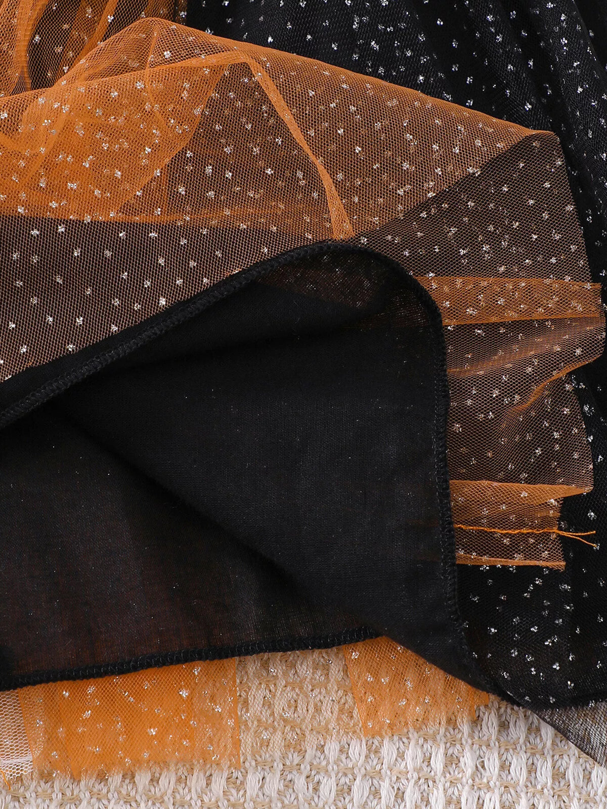 Close-up of the black skirt lining beneath the orange and black tulle layers.