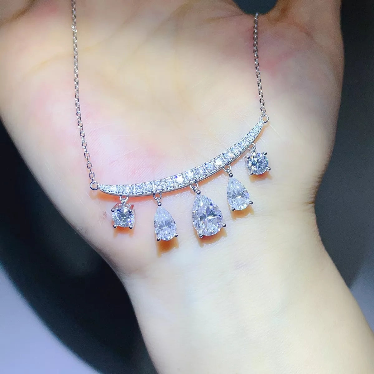 Silver-tone necklace with graduated teardrop stone pendants — detail view