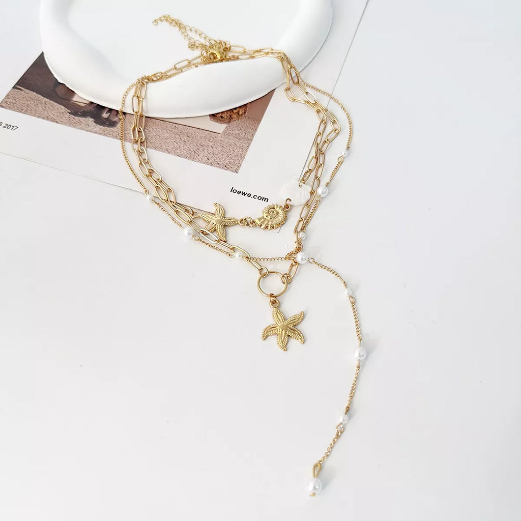 Layered gold-tone necklaces with starfish and shell charms